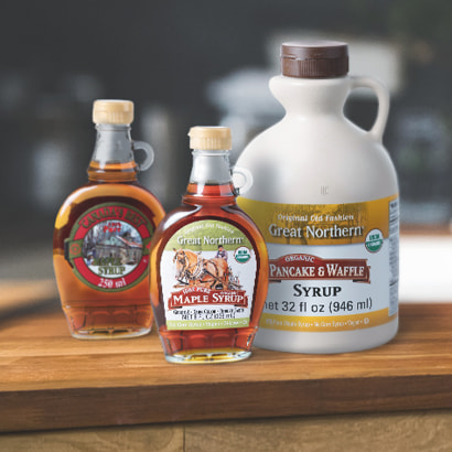 Two private label maple syrup glass bottles and one plastic jug.